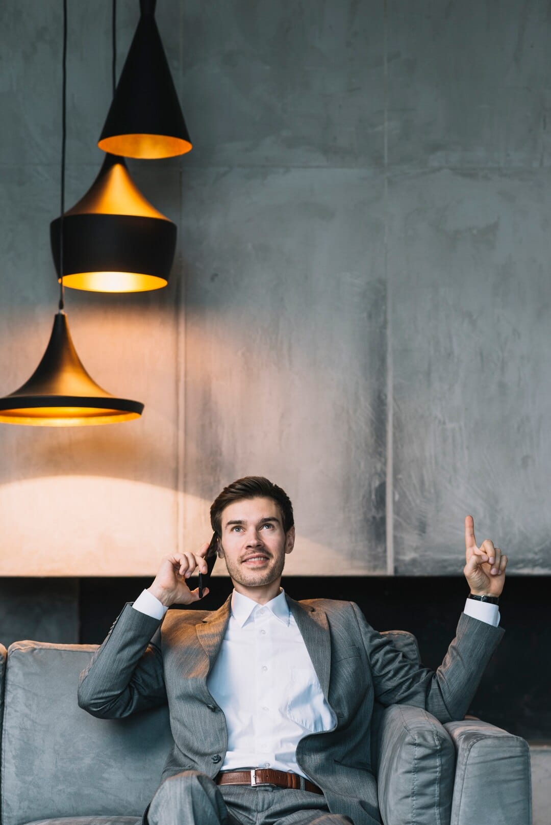 Young Businessman Pointing His Finger Upward While Talking Cellphone_23